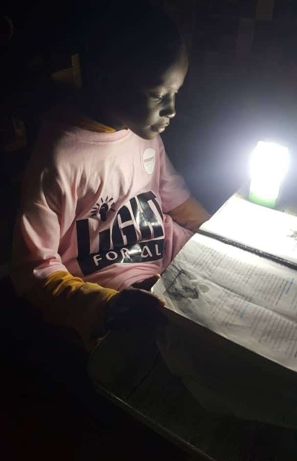 Student studying with portable light, Mali